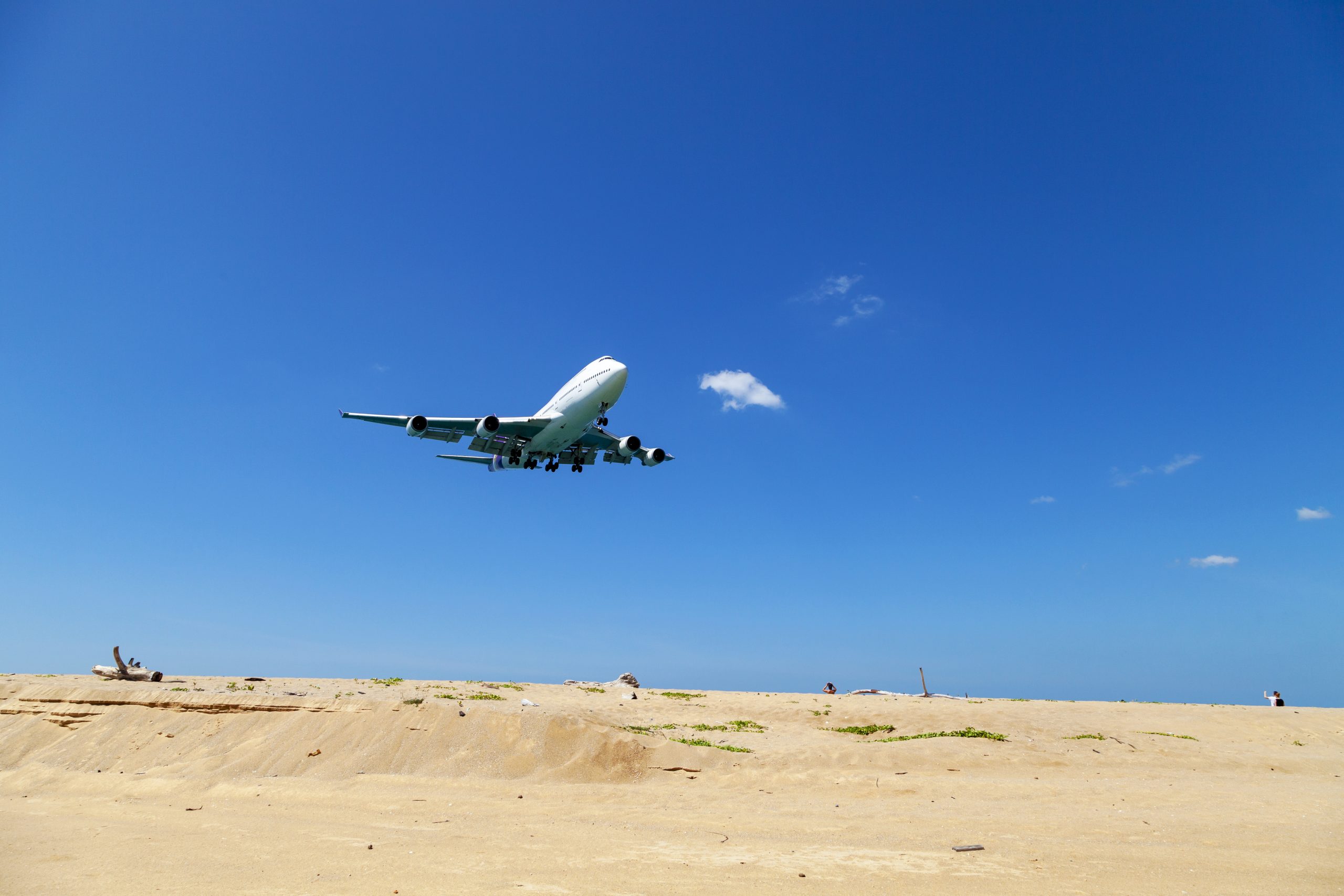 Commercial airplane landing above sea and clear blue sky over beautiful scenery nature background location at mai khao beach phuket thailand,Amazing landmark people take a photo at phuket airport.